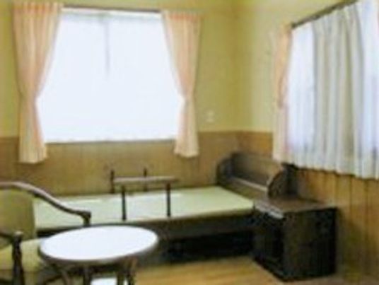 個室にベッドやテーブルセットが置かれ、二つの窓からは日が差している。