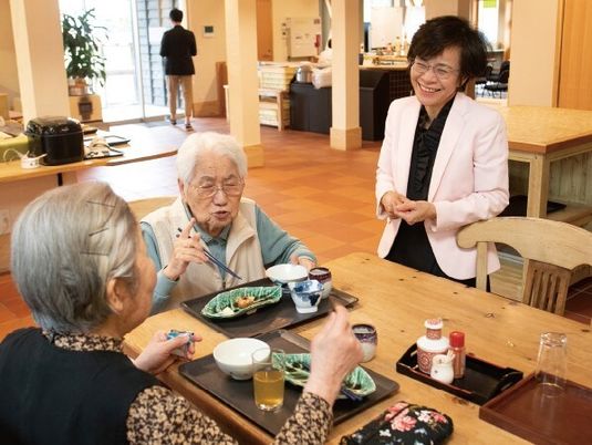 施設内で会話する利用者と地域の人の様子。コミュニティスペースの写真