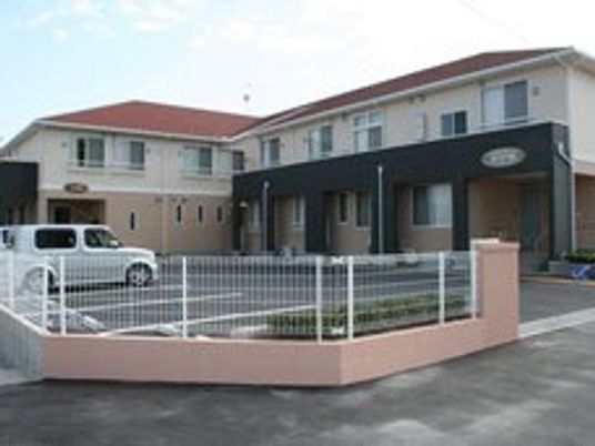 広い駐車場が付いた２階建ての建物は日当たりがいい場所にあり、エル字型。