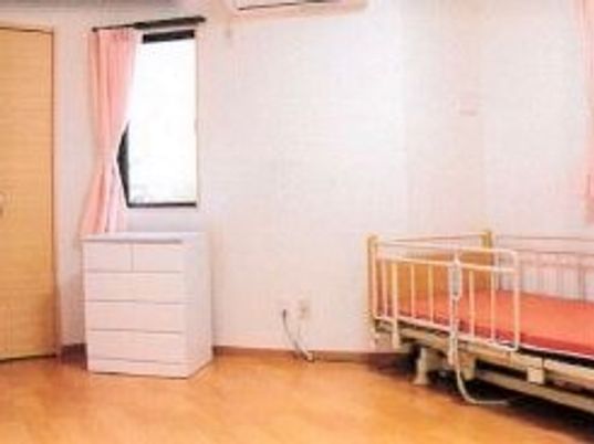 タンスと介護用ベッドがある部屋。窓がある様子が分かる