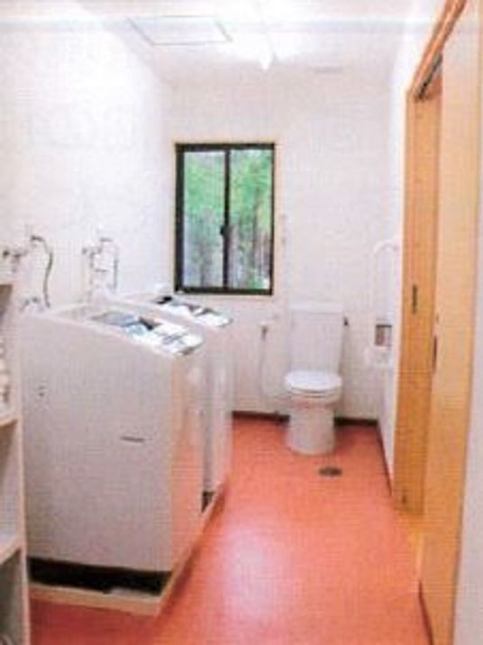 洗濯機が並んでいる場所。奥のほうにトイレがある様子が分かる
