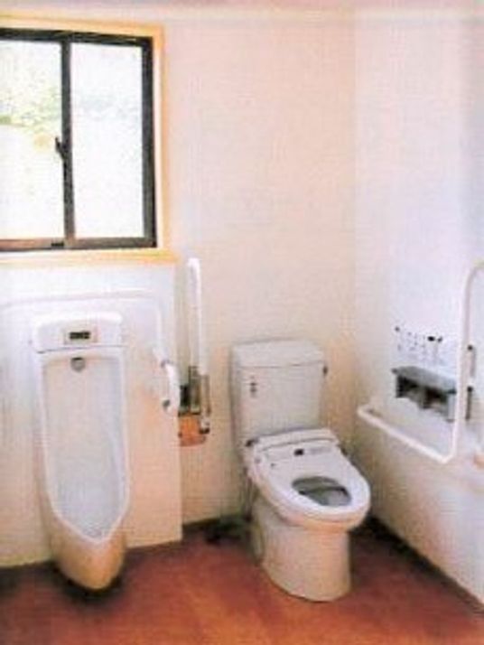 男性用・女性用の便器が置いてある多機能トイレ。手すりが両側に取り付けてある様子