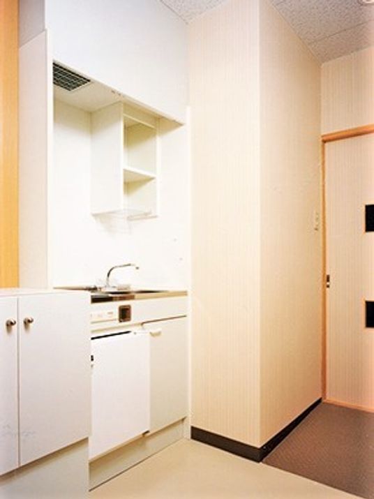 居室内に用意されたキッチンと水回り、部屋のドアを写した写真