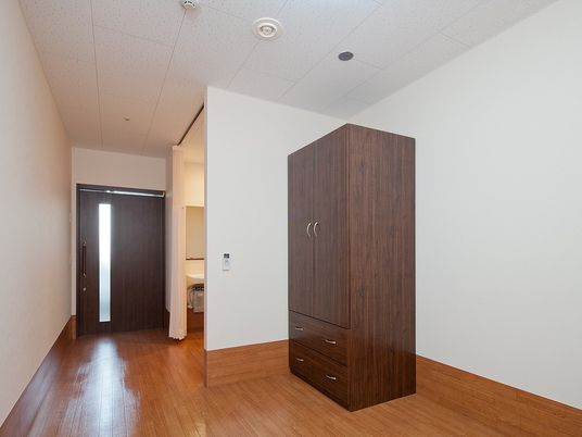 収納設備が置いてある居室の様子。トイレや洗面台があるワンルームタイプの部屋