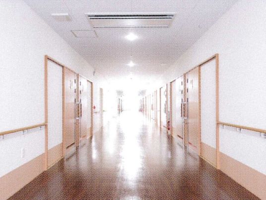 幅の広い手すりがついた施設内の様子。両側に個室のドアが見えている様子