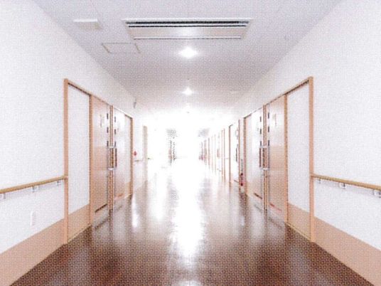 幅の広い手すりがついた施設内の様子。両側に個室のドアが見えている様子