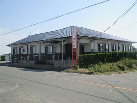 平屋建ての建物は瓦屋根を使用した和風の外観。玄関前にはスロープの設置もある。