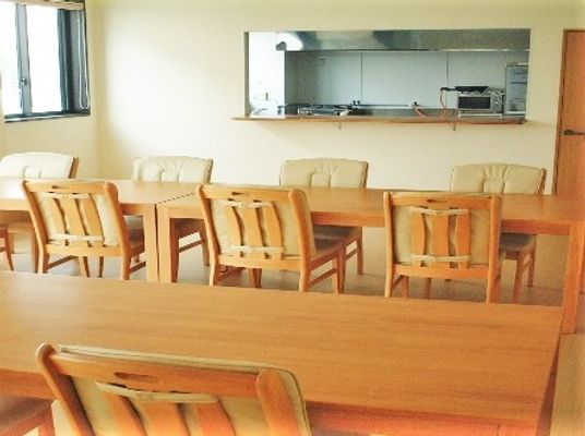 木製のダイニングテーブルが複数置かれた共有スペースは厨房とつながっていて日当たりがよく、明るい雰囲気。