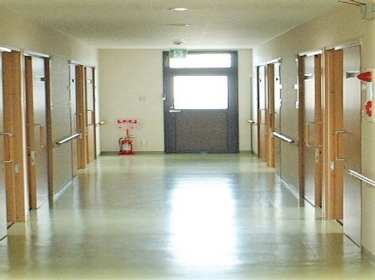幅の広い廊下の両サイドに手すりと居室があり、安全な設計。突き当りにも窓があるため明るい。
