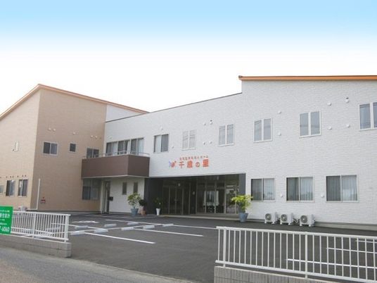 広い敷地内に大きな建物が建っている様子。複数台置ける駐車場スペースがある敷地
