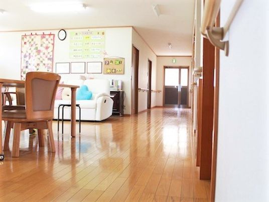 オールバリアフリーの床にいすやテーブルが置かれているリビングスペース