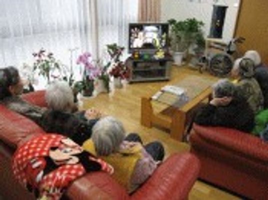 ソファに座ってテレビ鑑賞をしている複数名の入居者の様子。