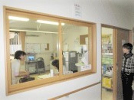 ヘルパーステーションには白衣を着たスタッフがいて、ドアのところに立っている女性と話をしている。