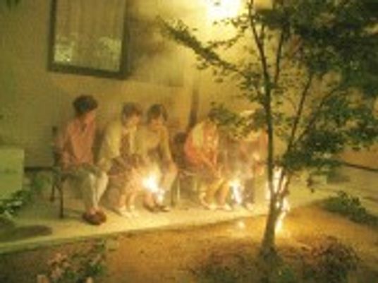 ホームの外で手持ち花火を楽しんでいる入居者の様子。