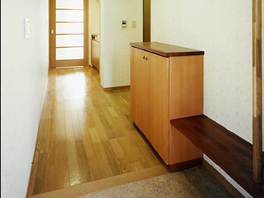 玄関にはベンチや靴箱があり、その奥にはミニキッチンが設置され、その横のドアはリビングにつながっている。