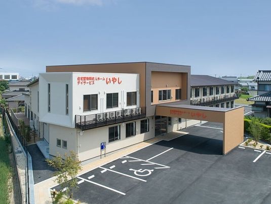 大きな車寄せが付き、駐車場もある2階建ての建物は白とベージュで日当たりのいい場所に建っている。