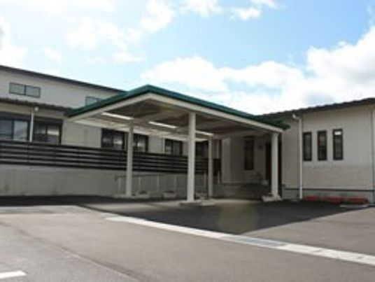 駐車場スペースがある建物の様子。平屋建てのような高さのない建物が写っている