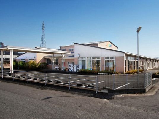 平屋建ての建物のある敷地内には大きな駐車場があり、車寄せも付いている。日当たりのいい場所に建っている。