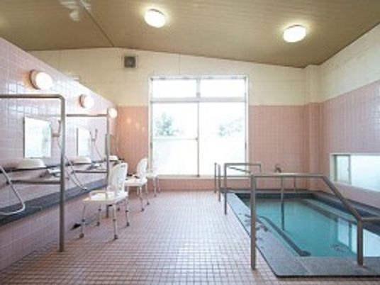 大きな浴槽が設置され、手すりが付き、シャワースペースにはシャワーチェアもある。