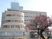 白を基調とした大きな建物の左側には半円の建物があり、1階部分の壁はほぼ窓となっている。