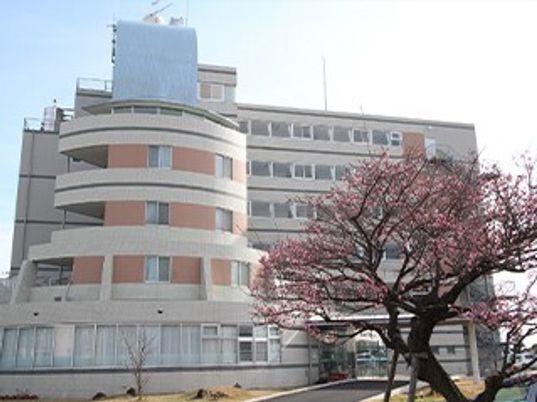 白を基調とした大きな建物の左側には半円の建物があり、1階部分の壁はほぼ窓となっている。