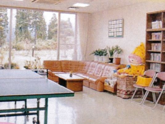 ソファや本棚、卓球台が置かれた交流室。大きな窓が付き明るい雰囲気。