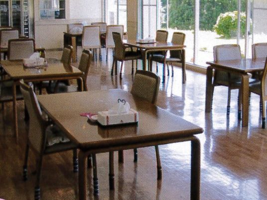 食堂には４人掛けのテーブルが複数並び、窓の外には緑が見える。