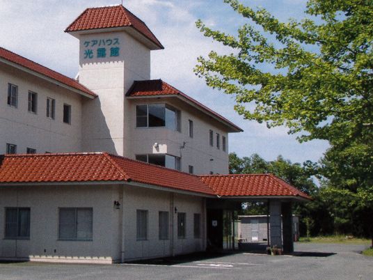 白い外壁に茶色い瓦屋根。周辺には緑が多く、駐車場も完備されている。