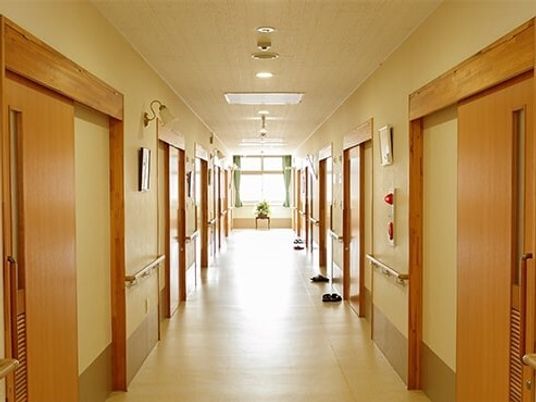 両サイドに手すりと居室のドアがあり、段差がなく、突き当りに大きな窓があるまっすぐな廊下。