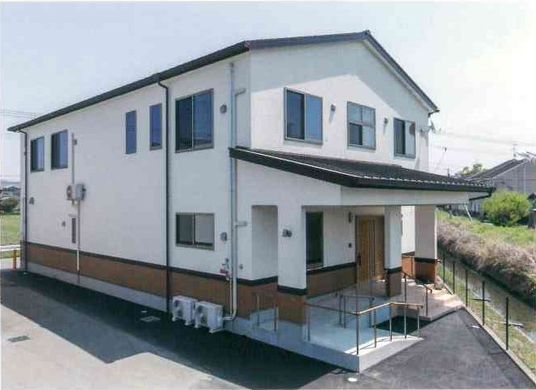 白い外壁で三角屋根の二階建て建築物