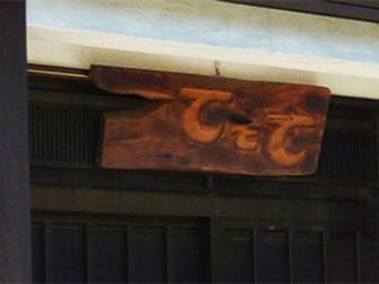 「てとて」と彫られた木製の看板がダークブラウンの外壁に設置されている。