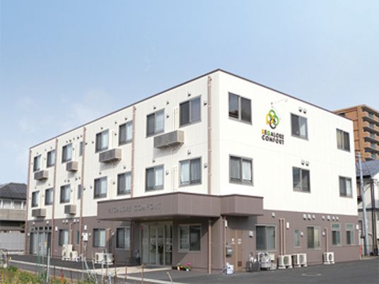 3階建ての建物はコンクリート製でどっしりとした頑丈な建物。白とブラウンの2色使い。