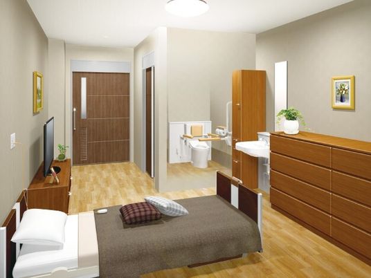 フローリングの居室にはタンスやクローゼット、テレビ、寝具付きのベッド、洗面所、トイレなどがあり、絵画も飾られている。