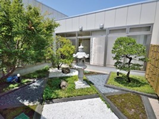 コンクリートと土が直線的なデザインに組み込まれたモダンなデザインの中庭