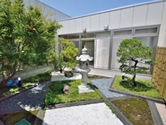コンクリートと土が直線的なデザインに組み込まれたモダンなデザインの中庭