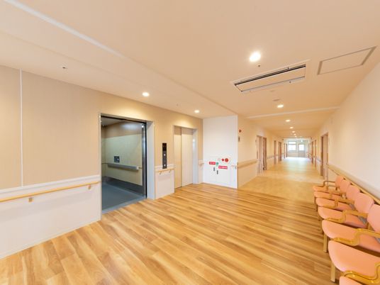 施設内の廊下とエレベーターホールの様子。休憩用の椅子が並べられている