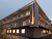 3階建ての建物の各フロアにベランダがあり、ホーム名が縦書きで外壁に書かれている。辺りが薄暗くなり、館内には明かりが灯っている。