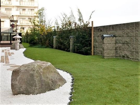芝生がきれいに手入れされ、左側には枯山水風の庭がある。