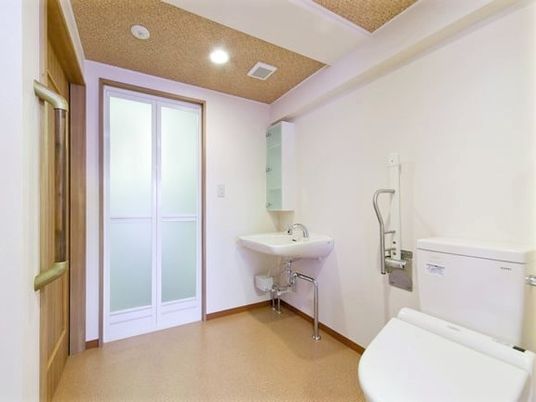 広いトイレには洗面所があり、可動式の手すりも付いている。