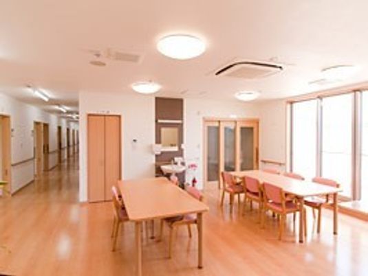 木製のダイニングテーブルが複数置かれた共有スペースはつながっていて日当たりがよく、明るい雰囲気。