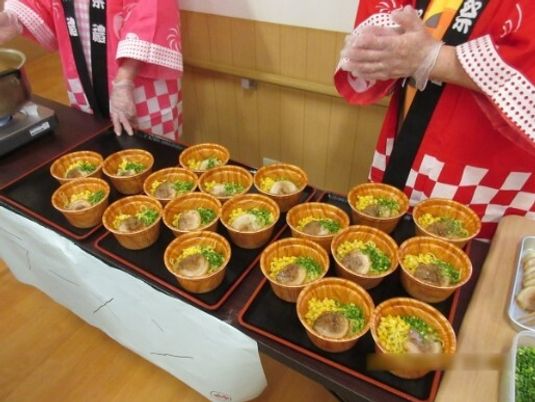 うどんのような丼ものがお膳に並べられている様子。イベントの時の食事