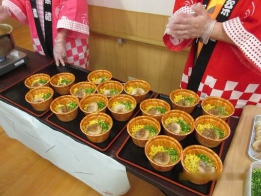 うどんのような丼ものがお膳に並べられている様子。イベントの時の食事