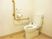 立ち上がり用の手すりが取り付けてある施設内のトイレの写真