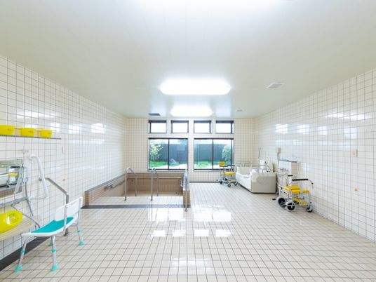 白いタイル張りの広い浴室には機械浴やシャワースペース、坂のようになっている大浴槽が設置されている。