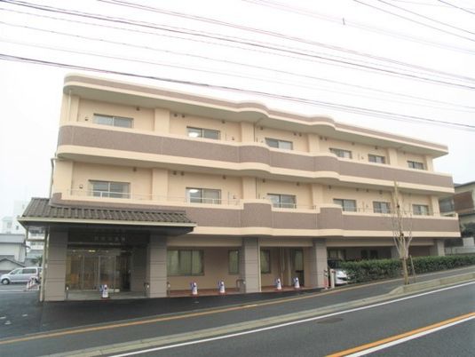 鉄骨造３階建ての建物の様子。やわらかい色合いが印象的な建物