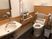 手すりと洗面台がある施設の介護仕様のトイレの様子。オールバリアフリーの床