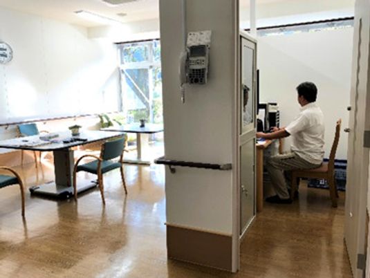 スタッフがいるスタッフステーションとリビングスペースの様子