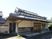 瓦屋根が付いた和風の建物は日当たりのいい場所に建っている。周囲には自然も多くある。