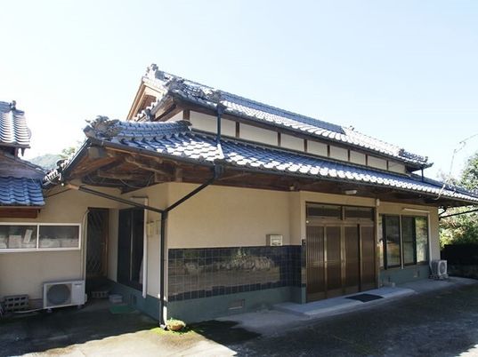 瓦屋根が付いた和風の建物は日当たりのいい場所に建っている。周囲には自然も多くある。