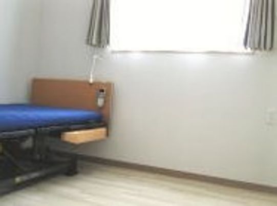 介護用ベッドが置かれたフローリングの居室には大きな窓が付いている。